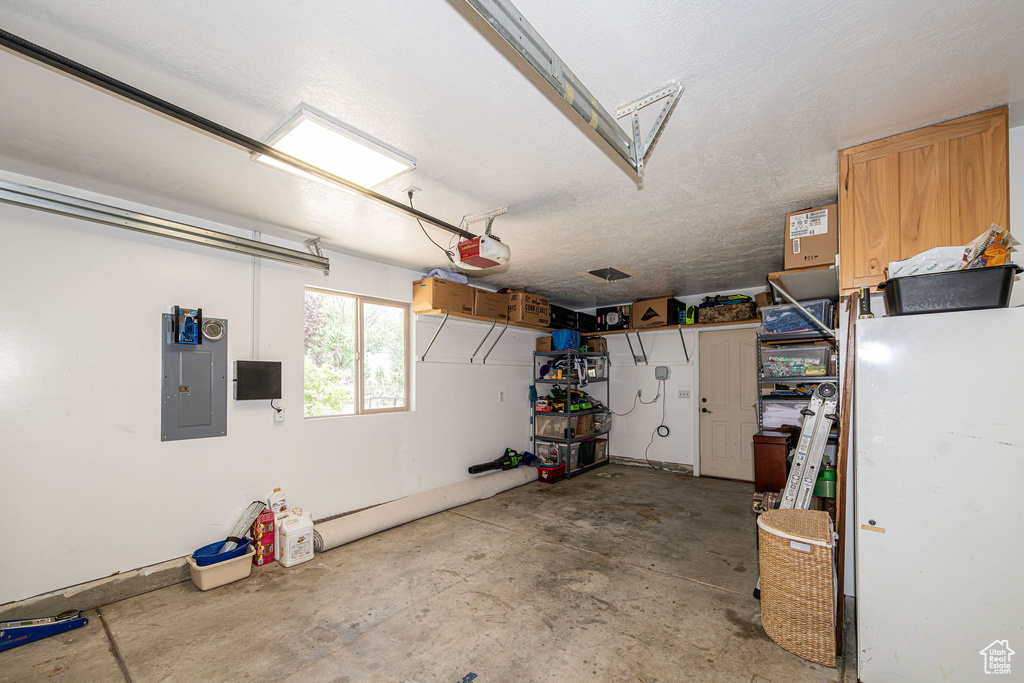 Garage with electric panel and a garage door opener
