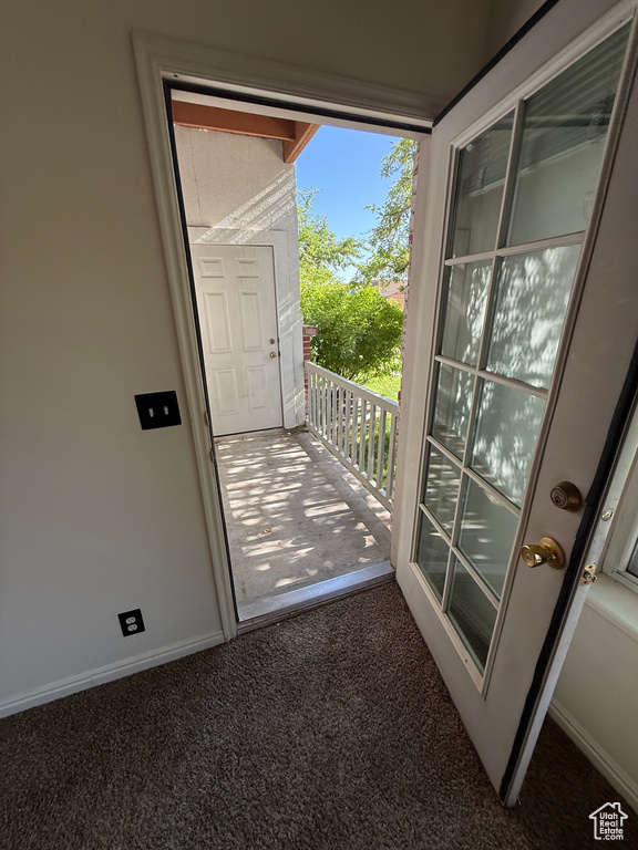 Doorway featuring carpet and baseboards