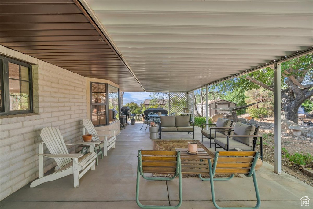 View of patio with an outdoor hangout area and a shed