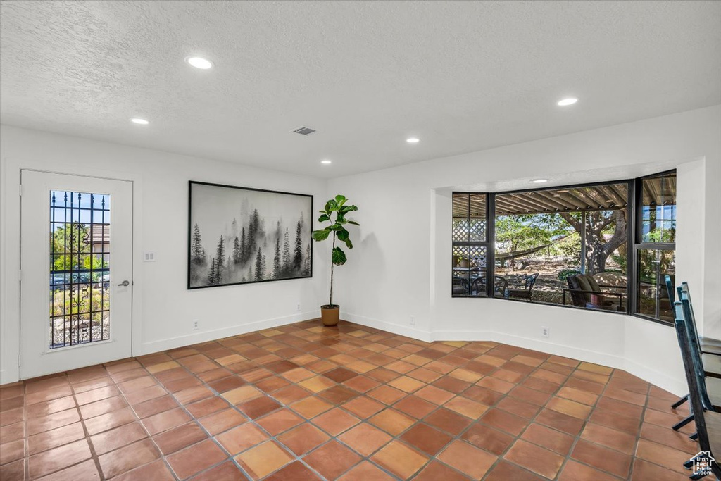 Tiled spare room featuring recessed lighting and a textured ceiling