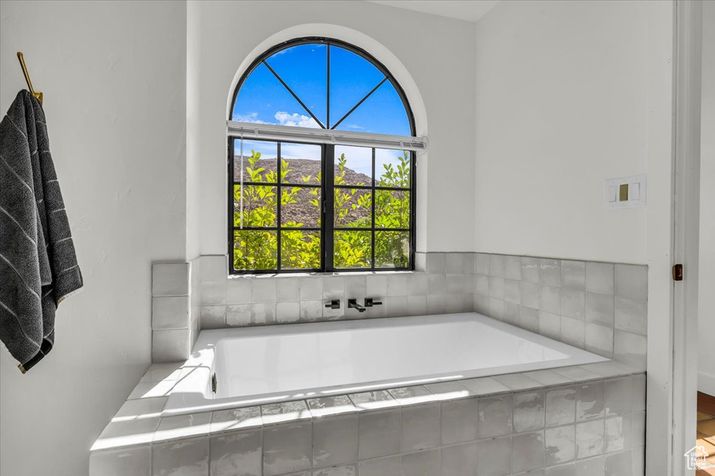 Full bath featuring a garden tub and healthy amount of natural light