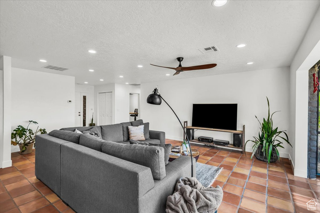 Tiled living area featuring recessed lighting, a ceiling fan, and a textured ceiling