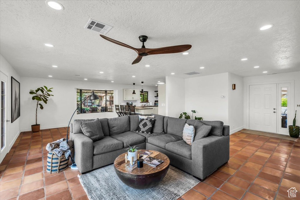 Tiled living area featuring plenty of natural light, recessed lighting, ceiling fan, and a textured ceiling