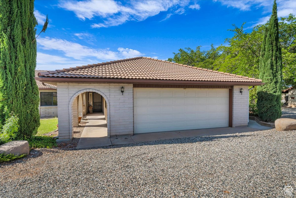 View of front of property featuring a tile roof and brick siding