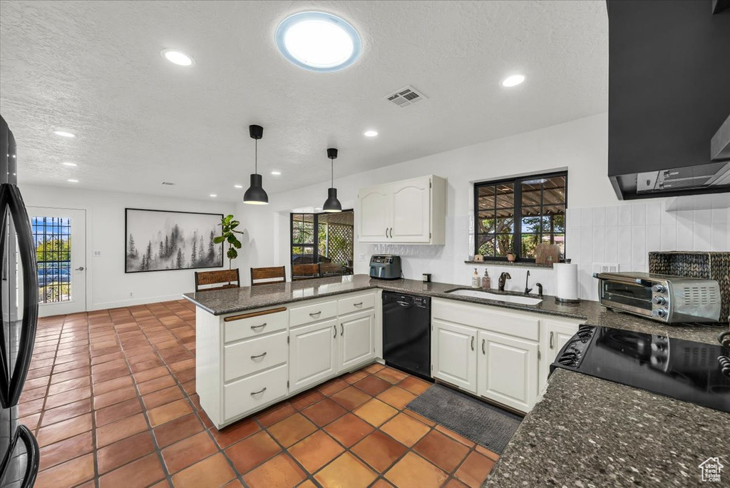 Kitchen featuring black appliances, a peninsula, white cabinetry, a textured ceiling, and recessed lighting