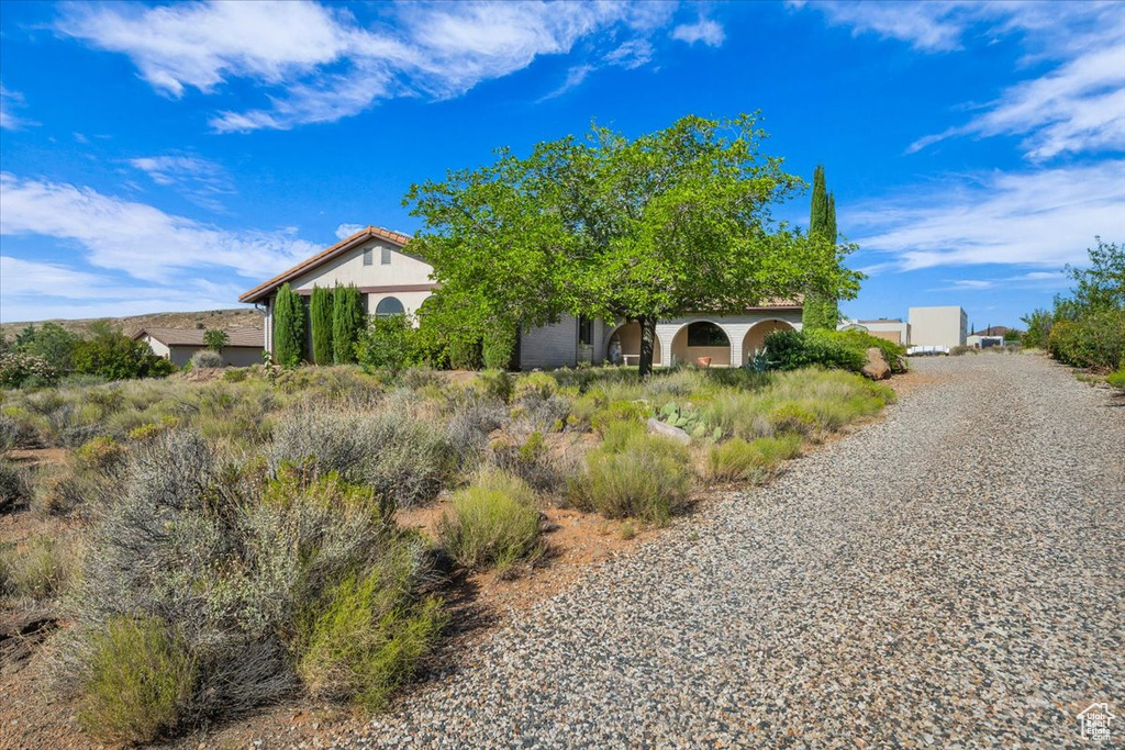 View of home's exterior featuring stucco siding and gravel driveway