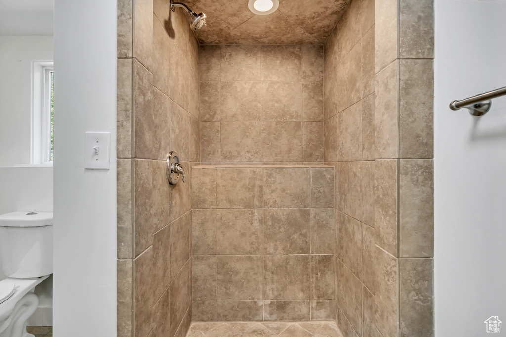 Bathroom featuring toilet and a tile shower