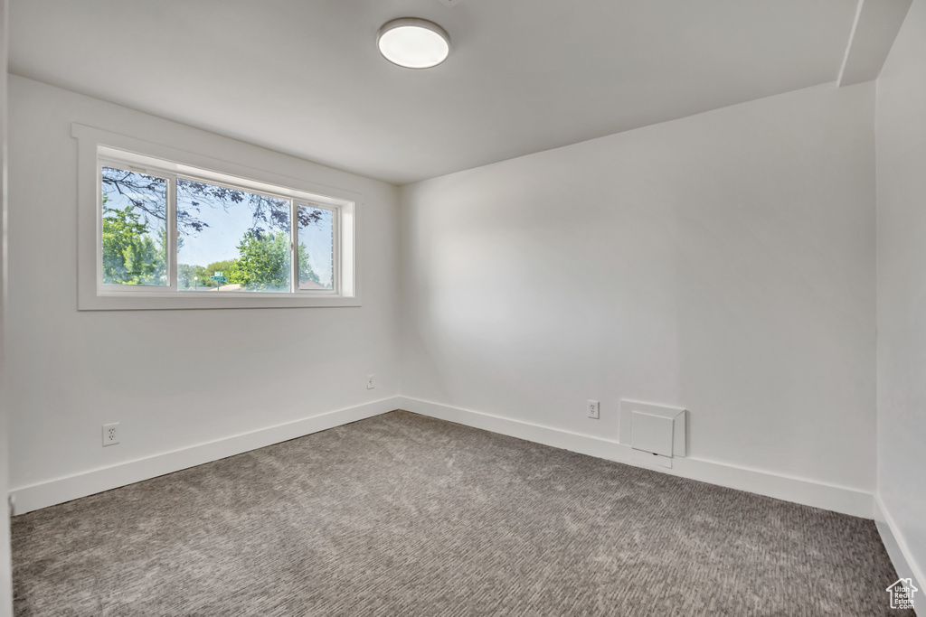 Carpeted spare room with baseboards
