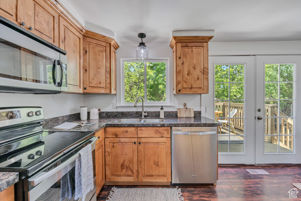 Kitchen featuring stainless steel appliances, french doors, dark wood-style flooring, and brown cabinetry