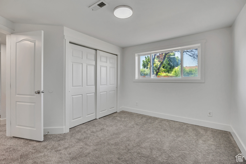 Unfurnished bedroom with carpet flooring and a closet