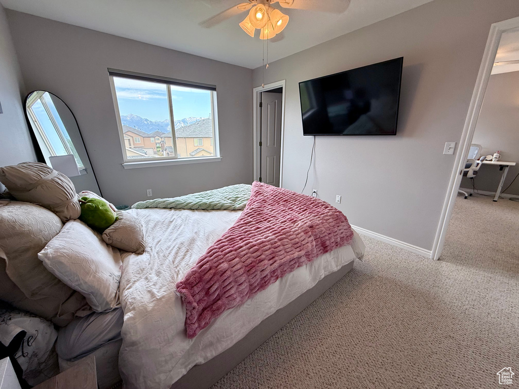 Bedroom with multiple windows, carpet floors, and a ceiling fan