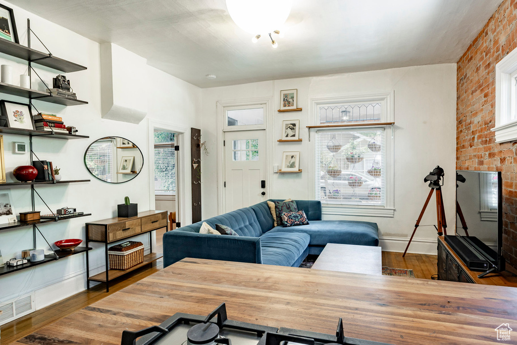 Living room with wood finished floors and brick wall