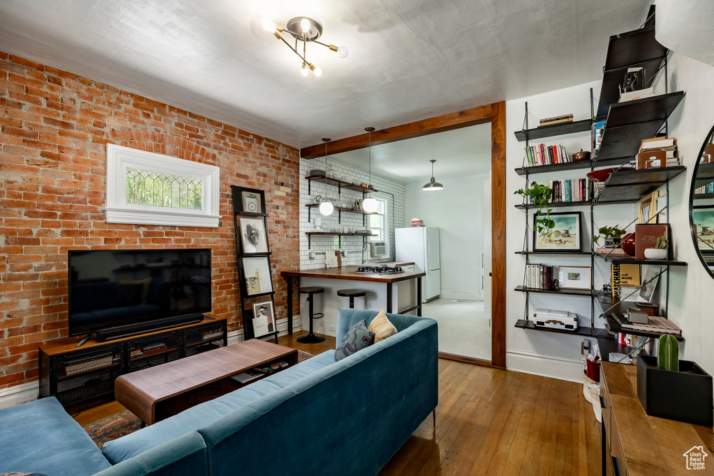 Living area featuring hardwood / wood-style floors, brick wall, and a fireplace