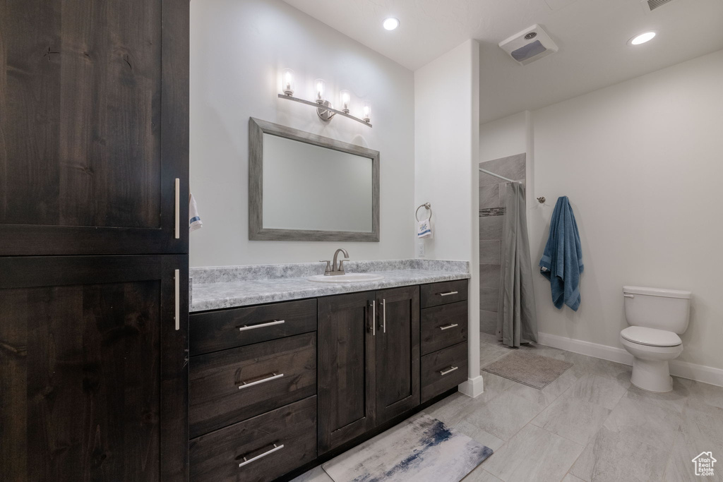 Full bath with vanity, curtained shower, and recessed lighting