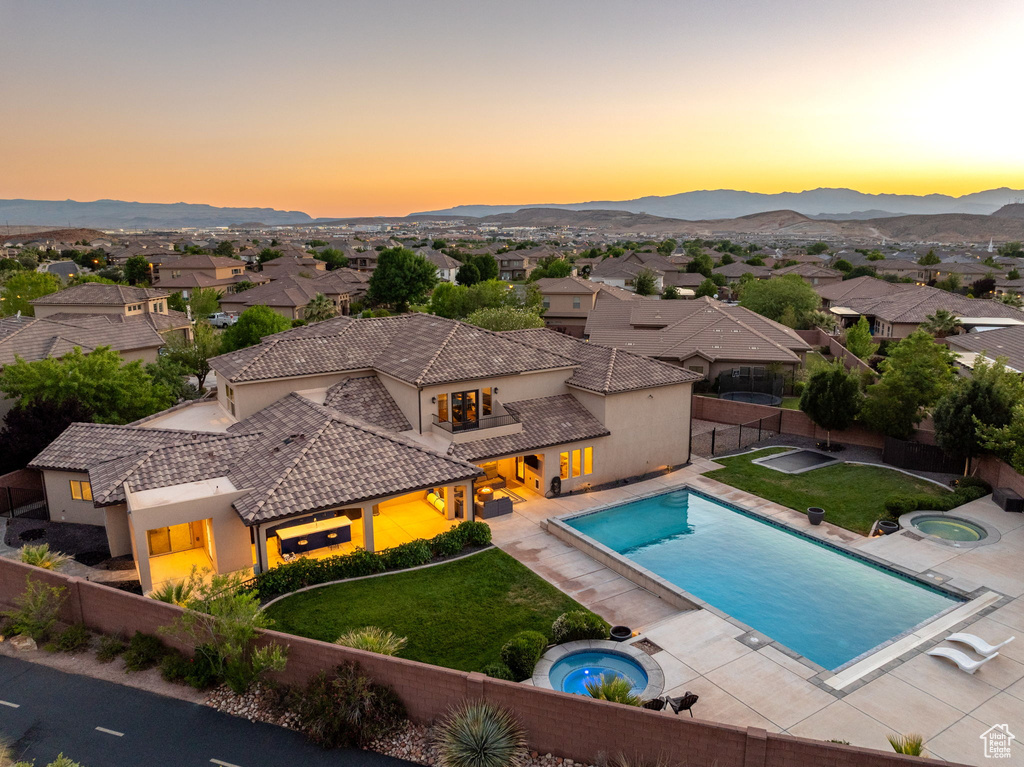 View of pool featuring an in-ground hot tub, a fenced backyard, a mountain view, and a patio