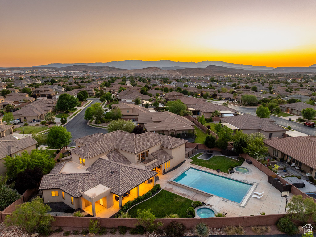 Aerial view of residential area featuring a mountainous background and a pool