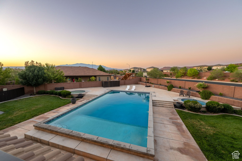 View of swimming pool featuring a fenced backyard, a patio area, an in-ground hot tub, and a mountain view