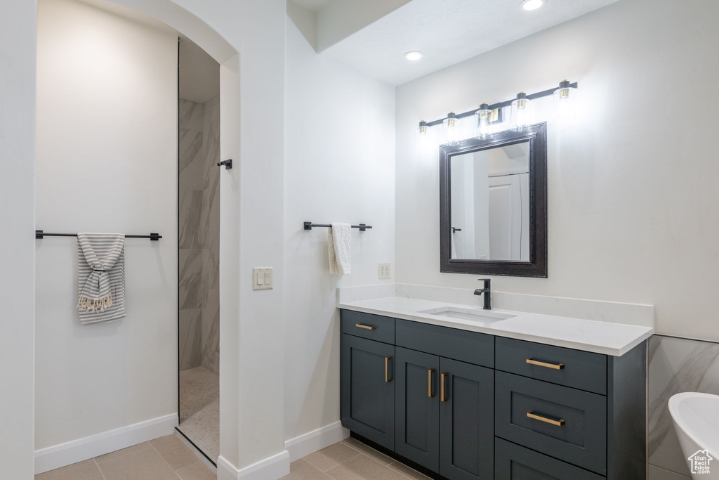 Full bath with a walk in shower, vanity, tile patterned floors, and recessed lighting