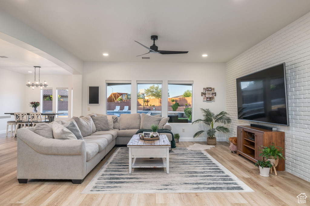 Living area featuring a ceiling fan, a chandelier, plenty of natural light, recessed lighting, and light wood-type flooring