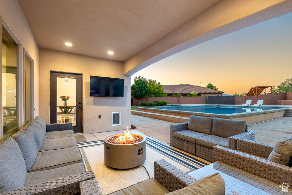 Fenced backyard featuring an outdoor living space with a fire pit and a patio area