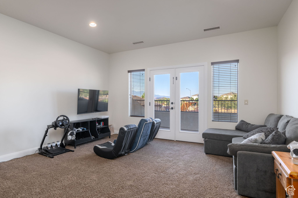 Carpeted living area with french doors and recessed lighting