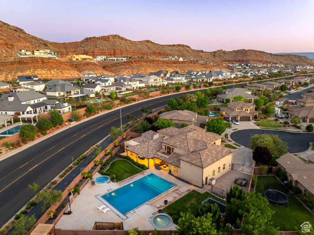 Aerial view at dusk of a residential view, a mountain view, and view of pool