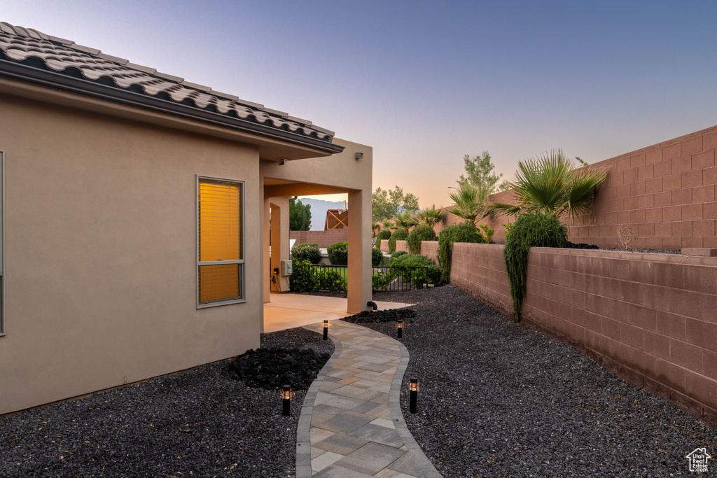 Yard at dusk with a fenced backyard and a patio area