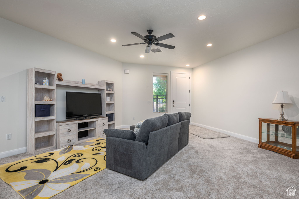 Carpeted living room with a ceiling fan and recessed lighting