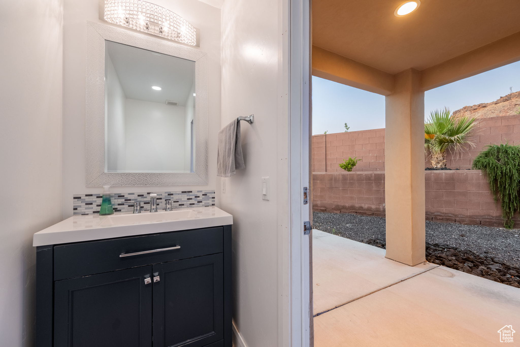 Bathroom with vanity, tasteful backsplash, and recessed lighting