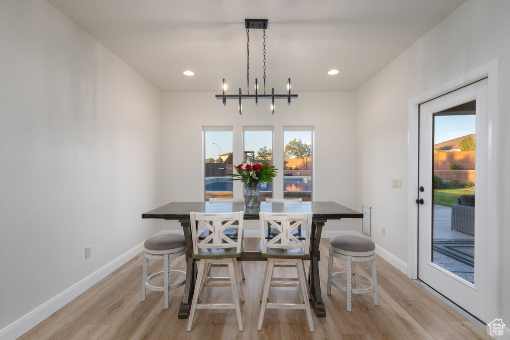 Dining area with light wood-style floors and recessed lighting