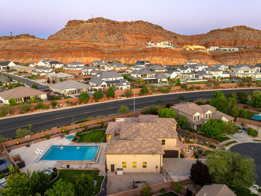 Aerial view at dusk of a mountain view, a residential view, and view of pool
