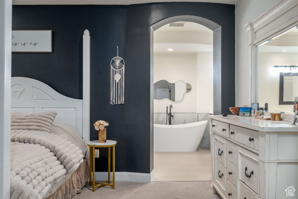 Bedroom featuring light colored carpet and arched walkways