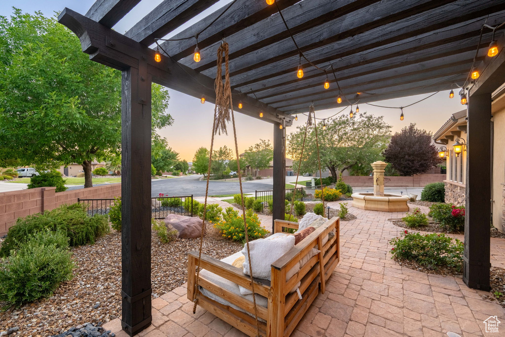 Patio terrace at dusk featuring a patio and a pergola