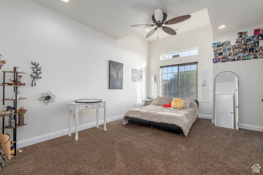 Bedroom featuring carpet flooring, a high ceiling, and a ceiling fan