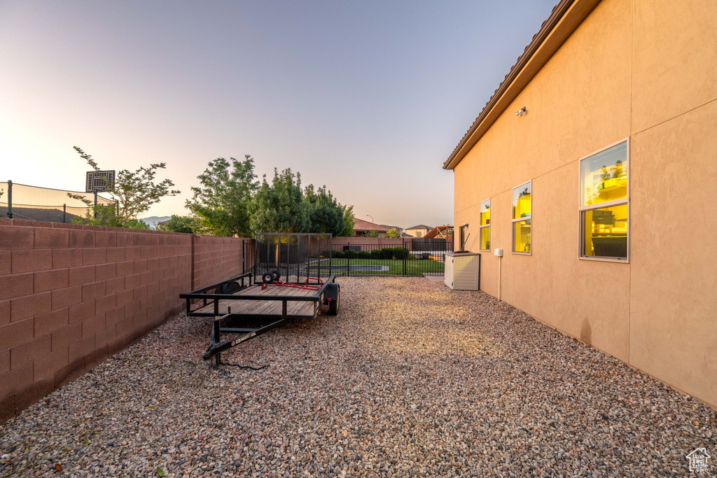 Yard at dusk featuring a fenced backyard