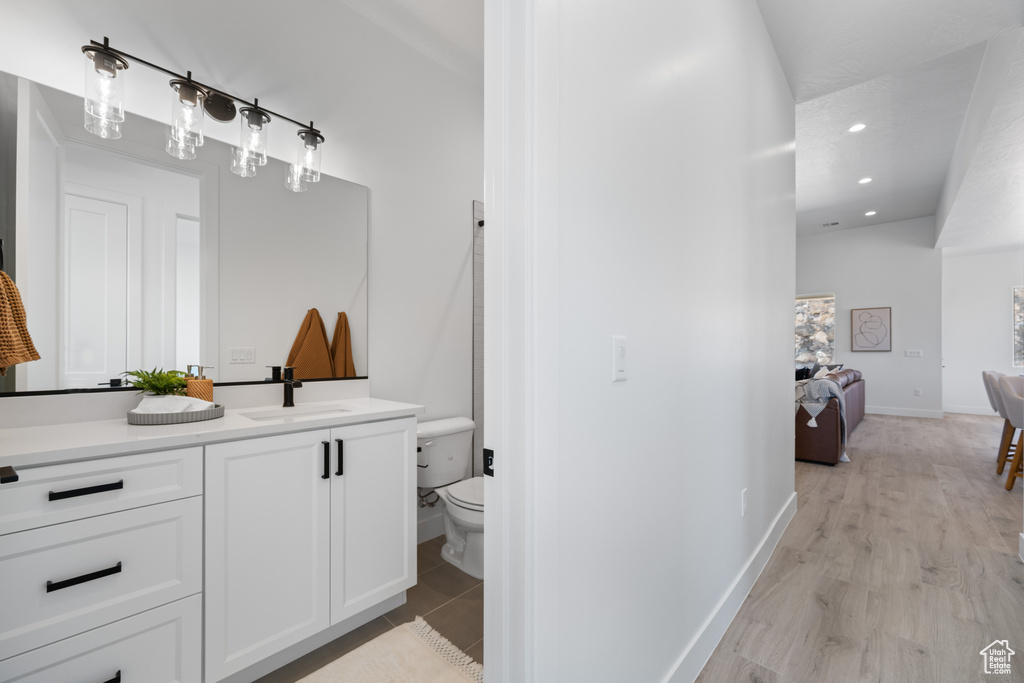 Ensuite bathroom with vanity, wood finished floors, and recessed lighting