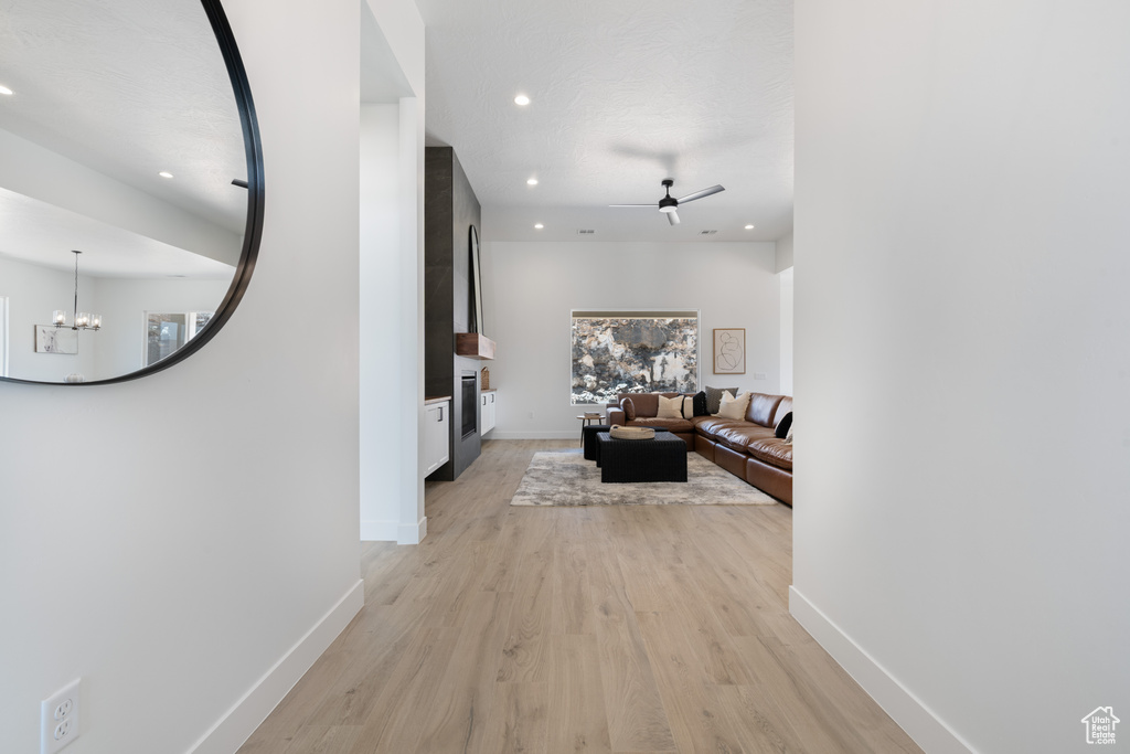 Hallway featuring recessed lighting, light wood-style floors, and a chandelier
