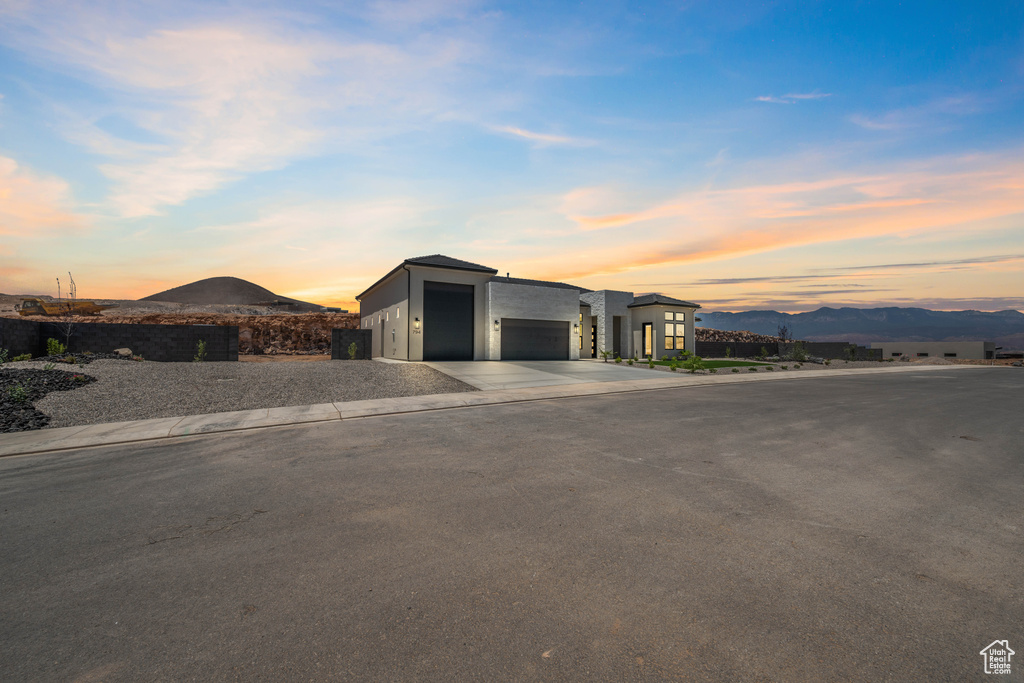 Contemporary house with a mountain view, driveway, a garage, and stucco siding