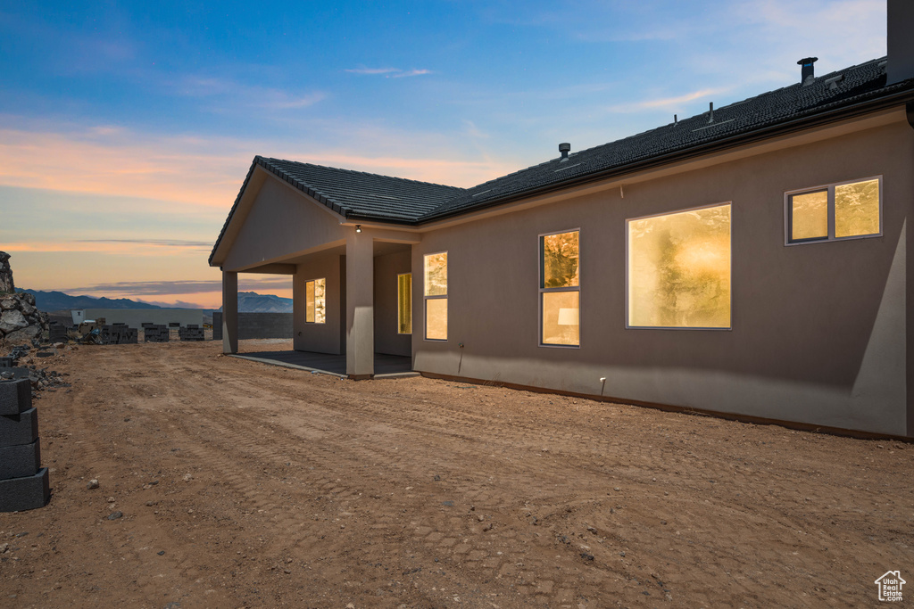 View of side of property with a patio area and stucco siding