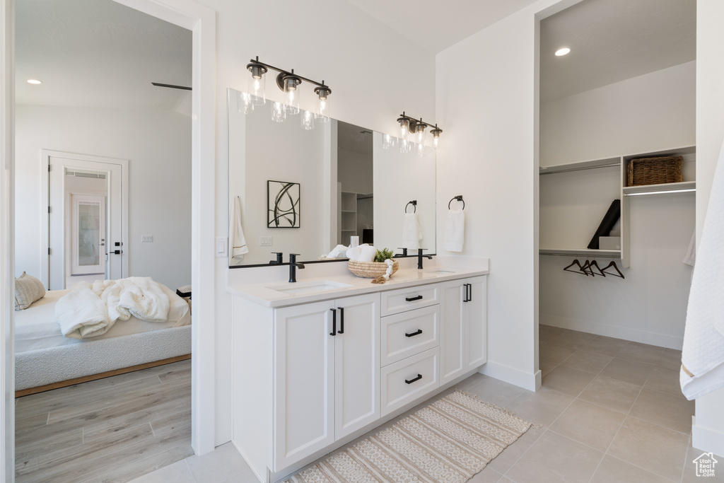 Ensuite bathroom with double vanity, recessed lighting, and tile patterned flooring