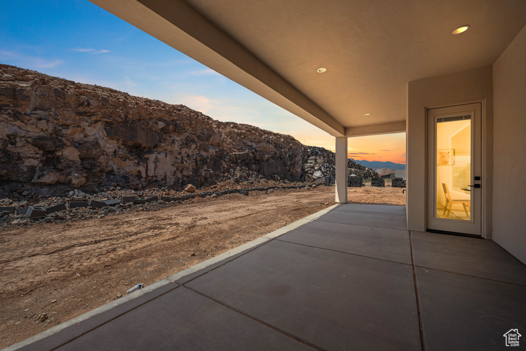 Patio terrace at dusk featuring a patio area and a mountain view