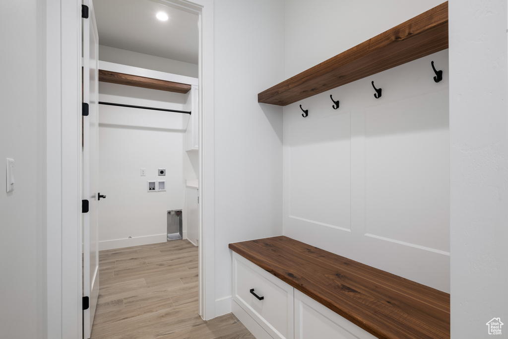 Mudroom with light wood-style flooring and baseboards