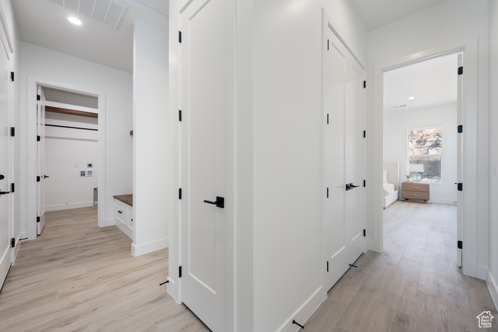 Corridor with light wood finished floors and recessed lighting