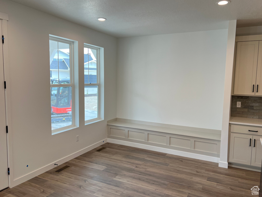 Unfurnished dining area featuring wood finished floors and recessed lighting