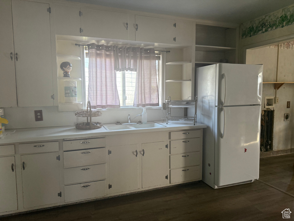 Kitchen featuring freestanding refrigerator, white cabinetry, open shelves, dark wood finished floors, and light countertops