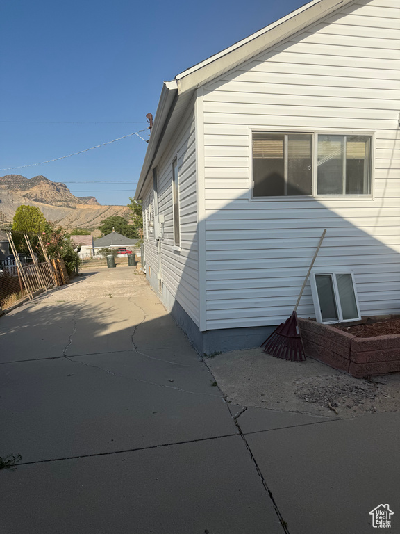 View of side of property with a mountain view and concrete driveway