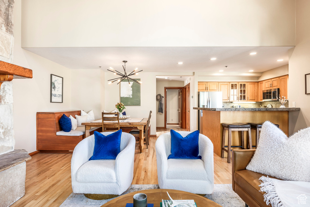 Living area featuring light wood-type flooring, a chandelier, and recessed lighting