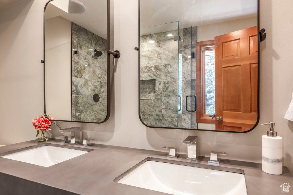Bathroom featuring a stall shower and double vanity