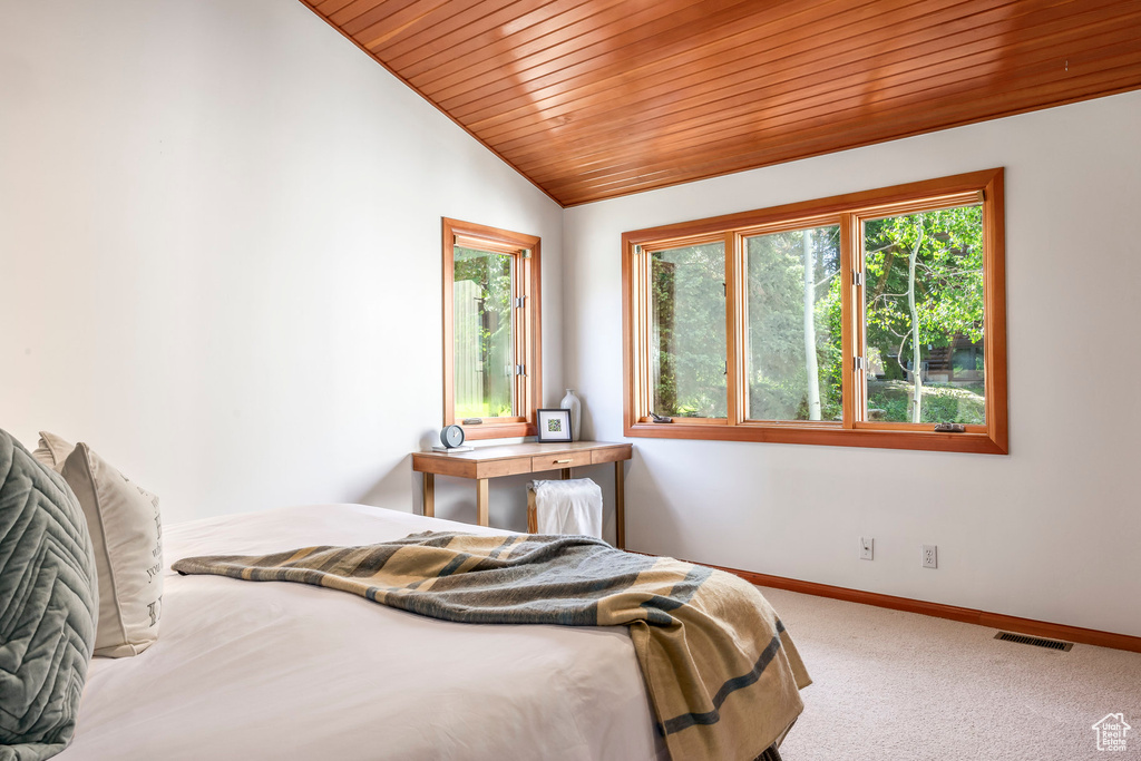 Carpeted bedroom featuring wood ceiling and lofted ceiling