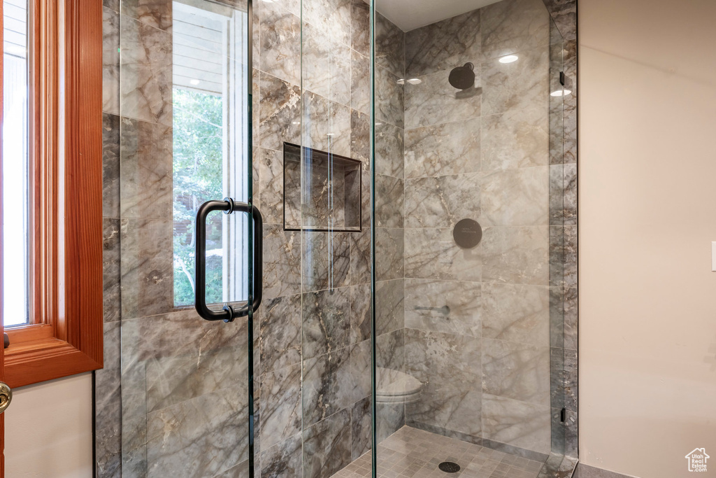 Bathroom with a shower stall and healthy amount of natural light